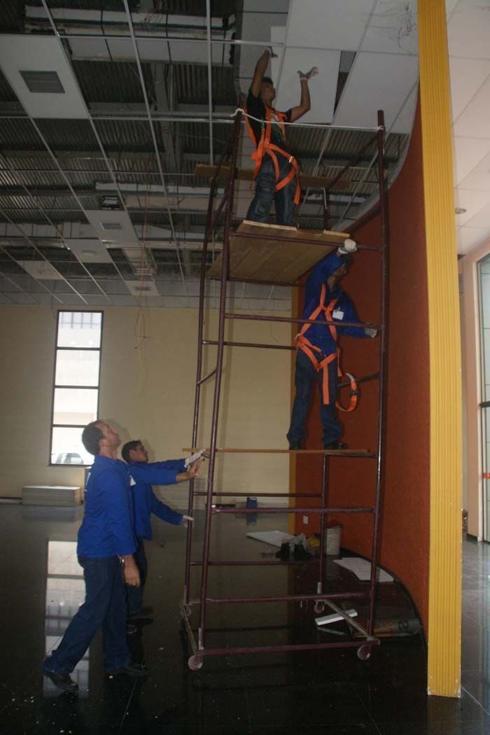 Trabalhadores executando reparos no forro do Bandeirão